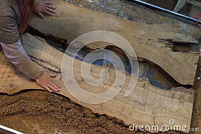 Craftsman marks wood with a ruler and pencil. Precision in handcraft aligns with the bespoke furniture trend. Stock Photo