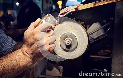 Craftsman during sanding of a crystal ashtrays Stock Photo