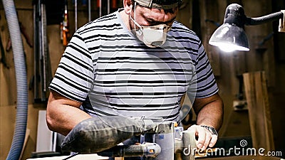 Craftsman working with grinding machine at wood workshop. Stock Photo