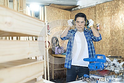 Craftsmans working together at carpentry shop. Carpenter Wearing sound protection at carpentry workshop Stock Photo