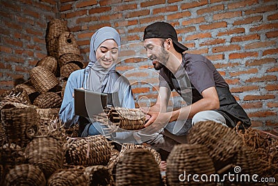 craftswoman in veil holding tablet and craftsman checking crafts Stock Photo