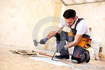 Crafty handyman removing old parquet Stock Photo