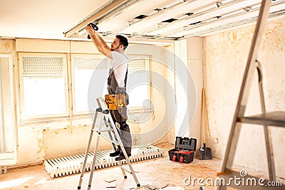 Crafty worker arranging ceiling construction Stock Photo