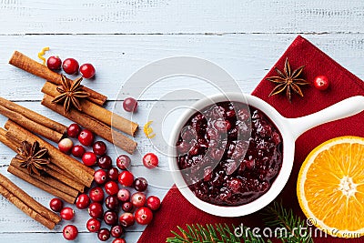 Cranberry sauce in ceramic saucepan with ingredients for cooking decorated with fir tree for Christmas or Thanksgiving day Stock Photo