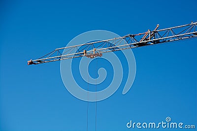 crane boom with rope in front of deep blue sky typical construction site background Stock Photo