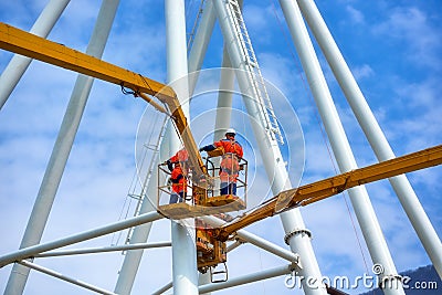 Crane booms and workers mount the structure Editorial Stock Photo