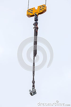 Crane hoisting block with hook on steel chain on the steel rope. Loading\unloading of building materials on construction building Stock Photo