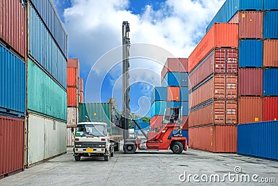 Crane lifter loading container box into truck in import export l Stock Photo