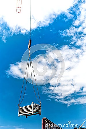 Crane lifting metalic structures of building of skyscraper. Details of construction site and tools Stock Photo