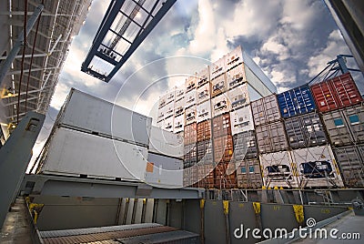 Crane lowering container to stack of containers. Stock Photo
