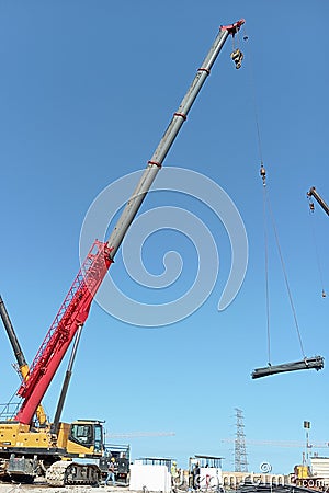 crane operator lifting iron at a construction project site Editorial Stock Photo