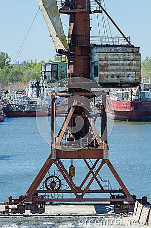 Crane in river port. Heavy cranes unloading metal to import. Steel delivery Editorial Stock Photo