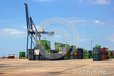 Cranes in the freight port of Alicante with lined shipping containers ready to be shipped Stock Photo