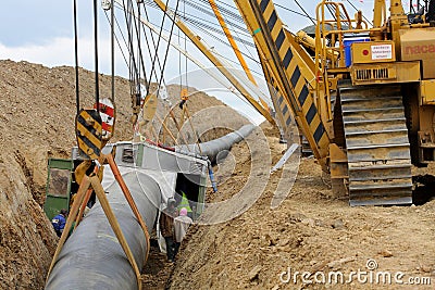 Cranes laying gas pipeline and welding cabin Editorial Stock Photo