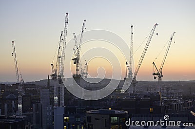 Cranes surrounded by buildings during the sunset in the evening in Edinburgh in Scotland Stock Photo