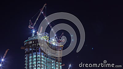Cranes working on big constraction site works of new skyscraper night timelapse Editorial Stock Photo