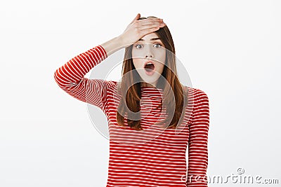 Crap, I totally forgot to do homework. Portrait of worried stunned girl slapping forehead with palm and dropping jaw Stock Photo