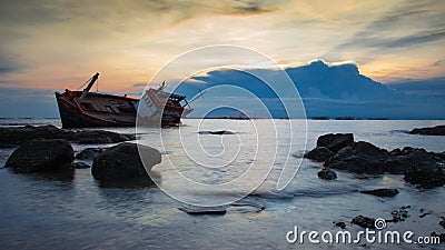 Crash boat on sea during sunset Stock Photo