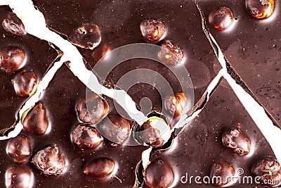 Crashed blach chocolate bar with large hazelnuts Stock Photo