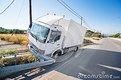 Crashed truck that hit crashed barrier on road, broken windshield, sunny day Stock Photo