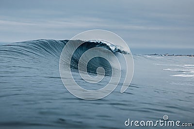Crashing glassy wave and cloudy sky. Breaking ocean waves, perfect swell for surfing Stock Photo