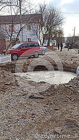 A crater on road filled with water after artillery shelling in Chernihiv. Editorial Stock Photo