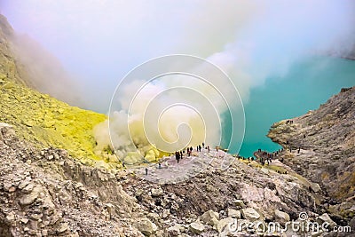 Crater of a volcano with a green sulfuric volcanic lake and volcanic smoke. View of the smoking volcano Kawah Ijen in Indonesia. M Stock Photo