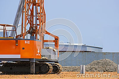 Pile driver machine lifting concrete piling for install industrial building structure in construction site Stock Photo