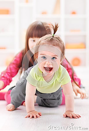 Crawling pigtailed toddler girl playing Stock Photo