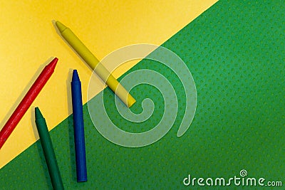 Crayons, blue, green, yellow and red at on yellow and green Stock Photo