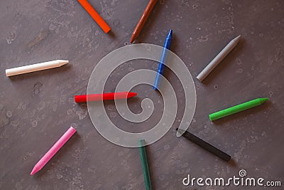 Crayons in a disorderly messy on dark background Stock Photo