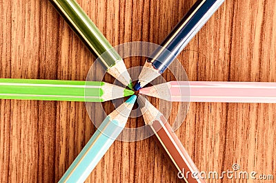 Crayons pointing to center. Symbolical image central power meeting at a point. Close-up of a selection of Multi Colored pencils, Stock Photo