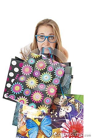 Crazy amusing young girl with shopping gift bags in the teeth. Stock Photo