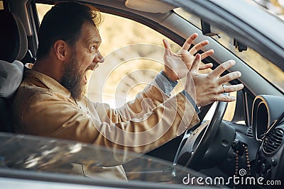 Crazy Angry Man Annoyed While Driving a Car. Mad Agrressive Driver Screaming Irritated with Traffic Stock Photo