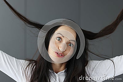 Crazy brunette woman makes grimaces on gray background Stock Photo