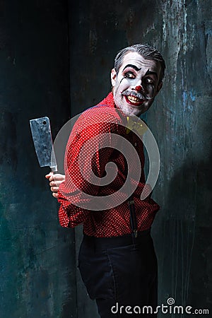 The crazy clown holding a knife on dack. Halloween concept Stock Photo