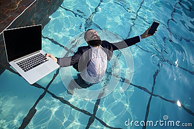 Crazy comic business. Excited business man in suit with laptop and mobile phone on swimming pool. Funny businessman Stock Photo