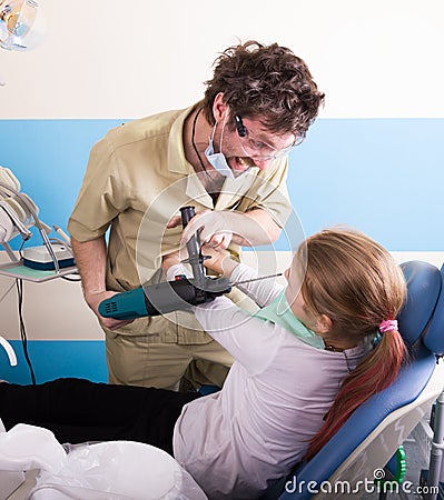 Crazy dentist treats teeth of the unfortunate patient. The patient is terrified. Stock Photo