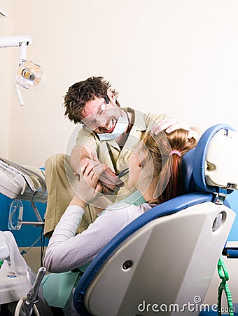 Crazy dentist treats teeth of the unfortunate patient. The patient is terrified. Stock Photo