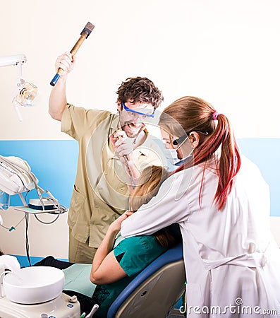 Crazy dentist treats teeth of the unfortunate patient. The patient is terrified. Stock Photo