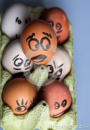 Crazy eggs terrified. Scared faces peering out of the egg tray Stock Photo