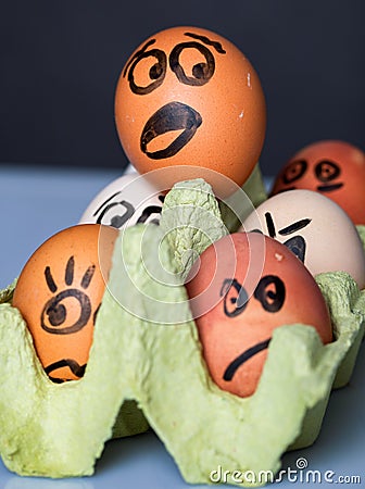 Crazy eggs terrified. Scared faces peering out of the egg tray Stock Photo