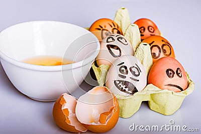 Crazy eggs terrified, Scared faces staring from egg tray at broken egg. Funny easter stories. Stock Photo