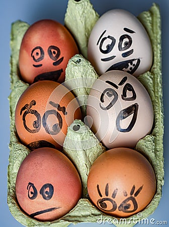Crazy eggs terrified. Scared faces peering out of the egg tray Stock Photo