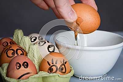 Crazy eggs terrified, Scared faces staring from egg tray at broken egg. Funny easter stories. Stock Photo