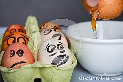 Crazy eggs terrified, Scared faces staring from egg tray at broken egg. Funny easter stories. Stock Photo