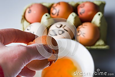 Crazy eggs terrified, Scared faces staring from egg tray at broken egg. Funny easter stories. Stock Photo