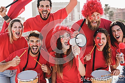 Crazy football fans having fun inside stadium for soccer match - Focus on center girl Stock Photo