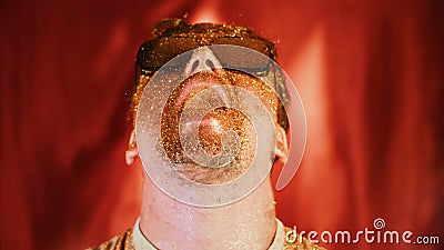 Crazy fun positive face man in gold glitter. Comical photo shake head funny person. Pouring powder from open mouth Stock Photo