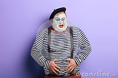 Crazy funny plump clown having a problem with his stomach Stock Photo